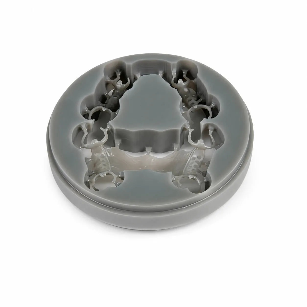 Grey dental wax disc with milled removable partial denture framework pattern